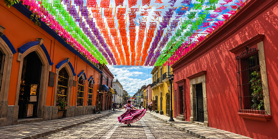 Andador turístico de Oaxaca con papel picado y bailarina con traje típico